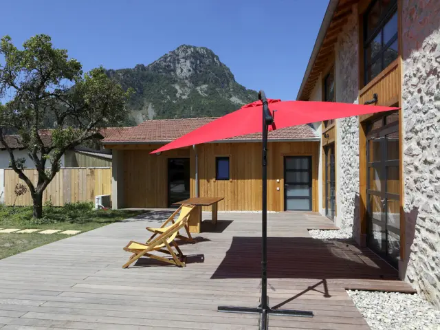 Wooden terrace with red umbrella and lounge chairs