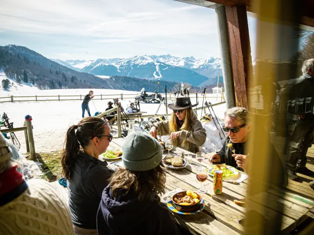 Groupe de personnes mangeant à une table en plein air en montagne