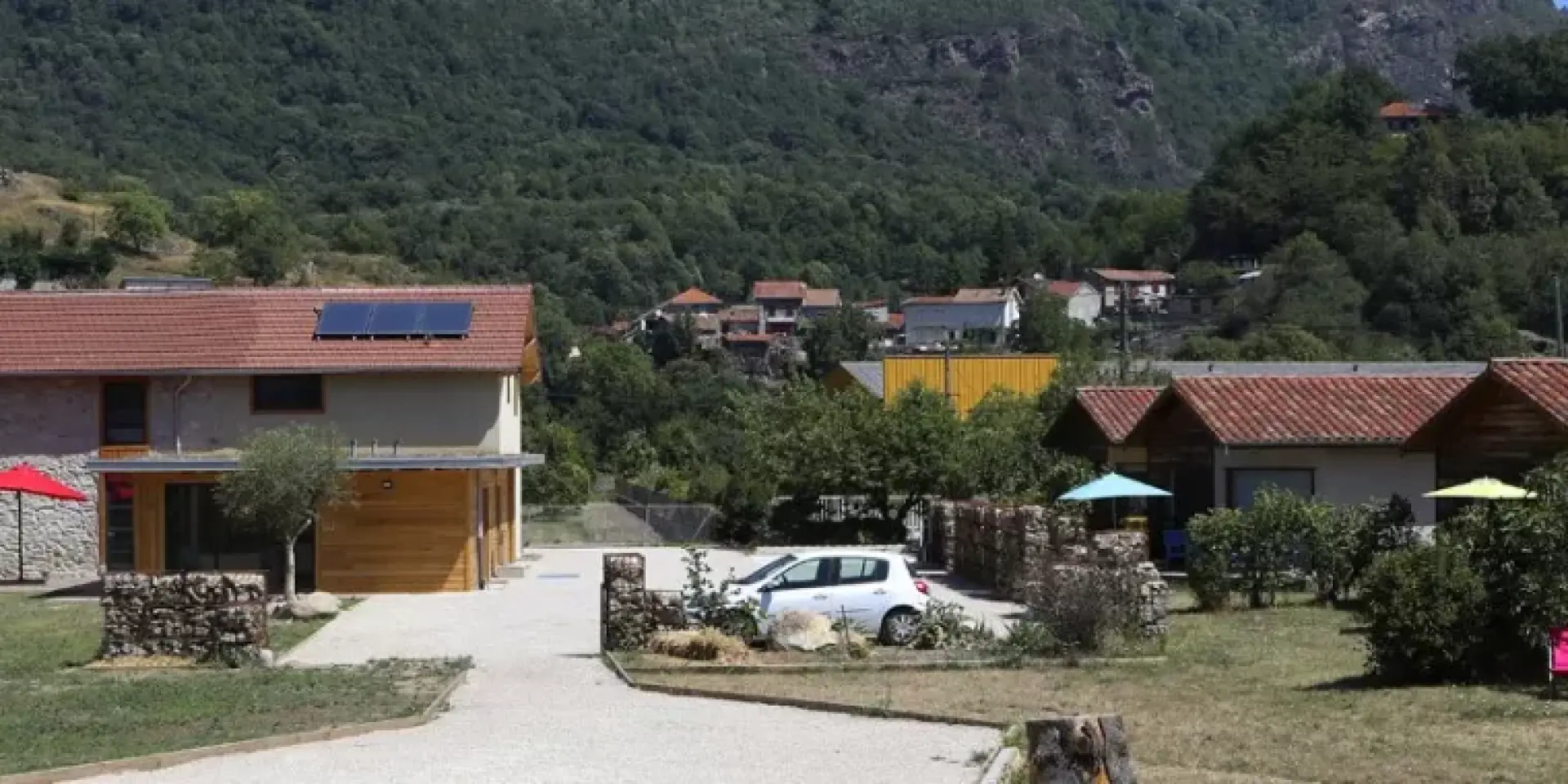 Village de vacances avec des maisons en bois et des tables sous des parasols