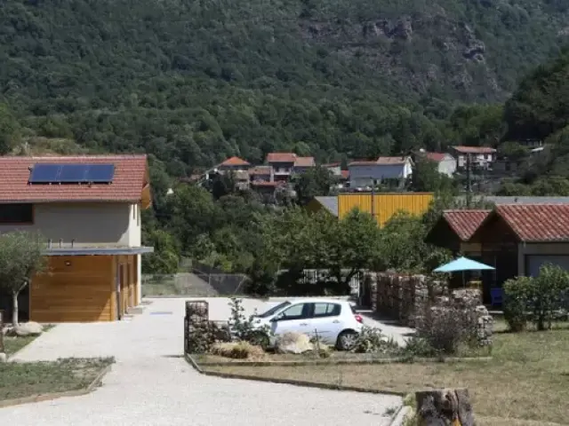 Village de vacances avec des maisons en bois et des tables sous des parasols