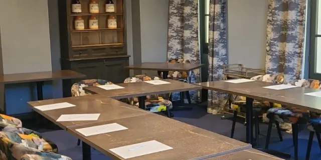Salle de réunion avec tables et chaises disposées pour une réunion