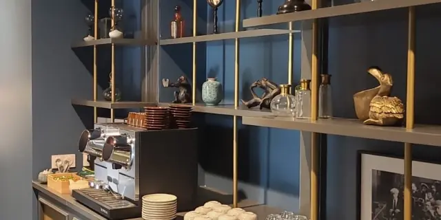 Une bibliothèque avec des étagères remplies d'objets décoratifs et un coin café