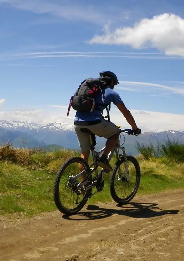 Deux personnes faisant du vélo sur un chemin de terre en montagne