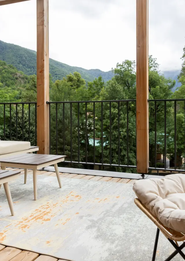 Terrasse en bois avec vue sur une forêt et des montagnes