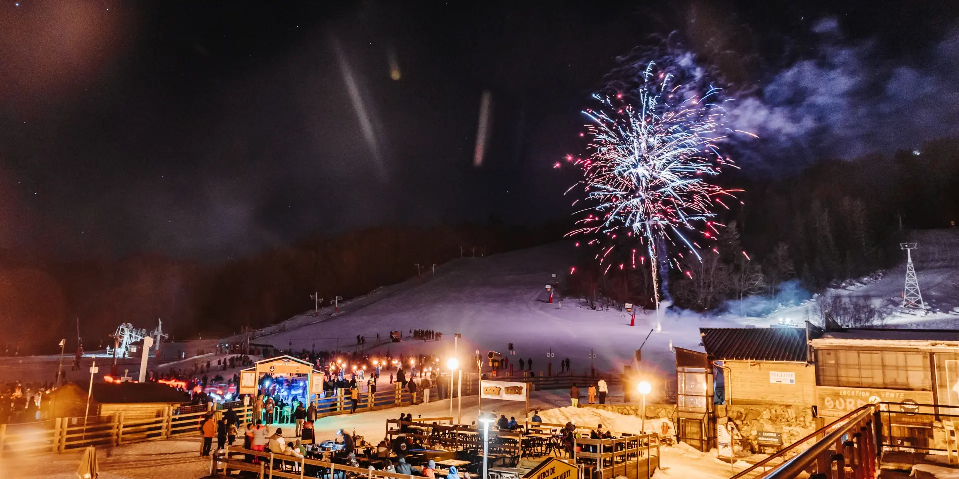 Feu d'artifice illuminant une station de ski enneigée