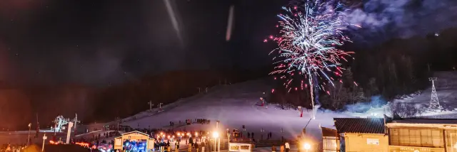 Feu d'artifice illuminant une station de ski enneigée