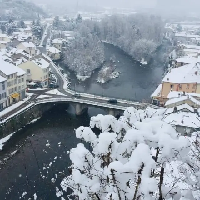 Vue aérienne d'un village enneigé avec une rivière qui le traverse