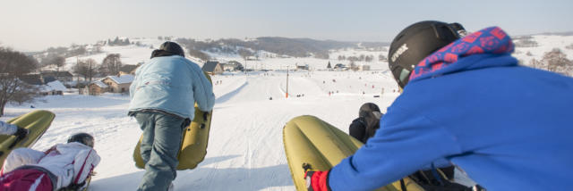 Deux personnes pratiquent l'airboard sur une piste de ski