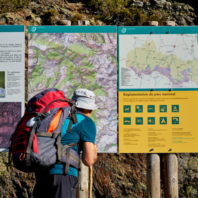 Pèlerin de St Jacques de Compostelle observe des panneaux du Parc National des Pyrénées