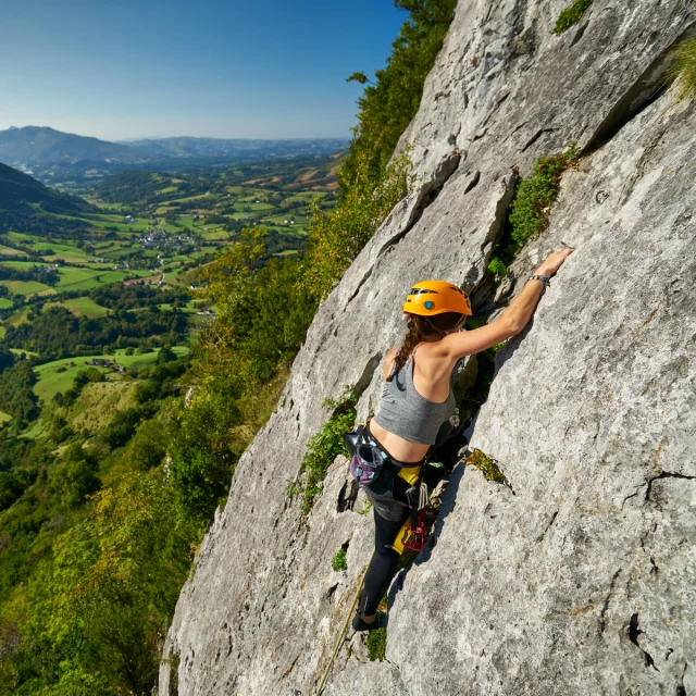 Une sportive escalade la falaise d'Arguibelle à Lanne en Baretous
