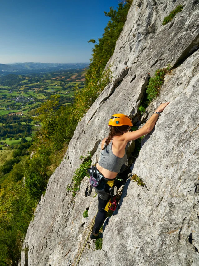Una deportista escalando el acantilado Arguibelle en Lanne en Baretous