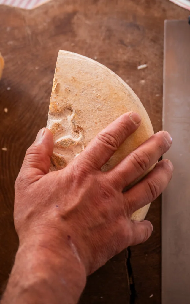 fromage coupé en deux sur un plateau en bois qui est posé sur une table