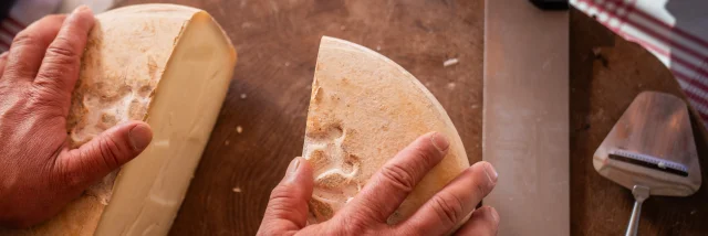 fromage coupé en deux sur un plateau en bois qui est posé sur une table