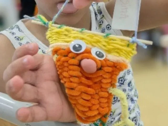 enfant qui tient une marionnette faite en tissu