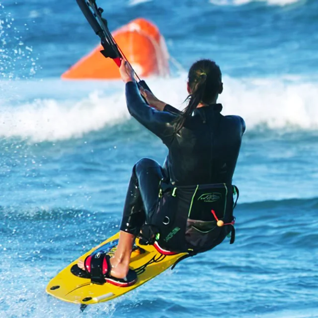 Personne pratiquant le kitesurf sur la mer, tirée par une voile, au large de la côte.