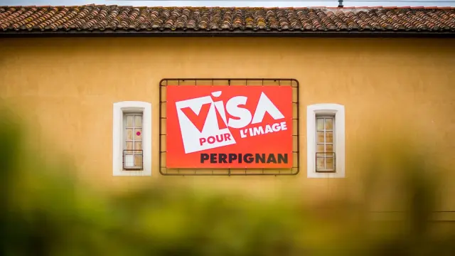 Panneau du festival Visa pour l’Image sur la façade d’un bâtiment à Perpignan.