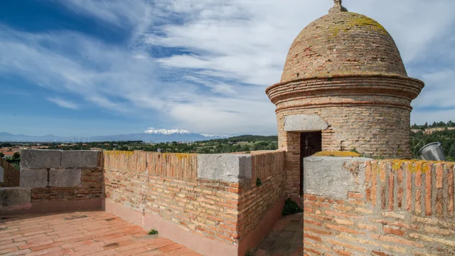 Chemin de ronde et échauguette en brique de la forteresse de Salses, avec vue sur le Canigó enneigé à l’horizon.