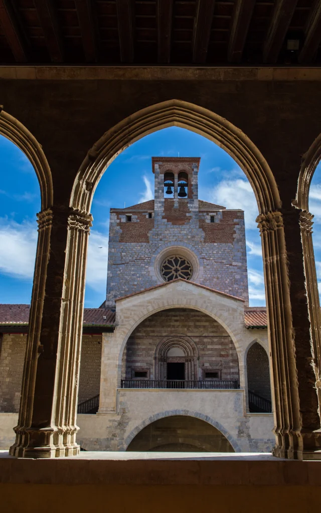Vue du clocher du Palais des Rois de Majorque à Perpignan à travers les arches gothiques de la galerie intérieure.