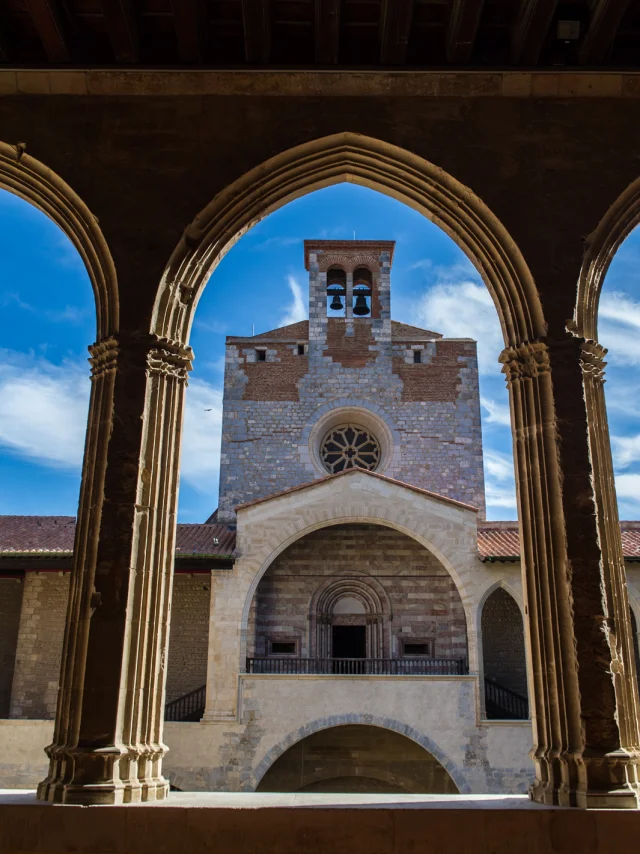 Vue du clocher du Palais des Rois de Majorque à Perpignan à travers les arches gothiques de la galerie intérieure.