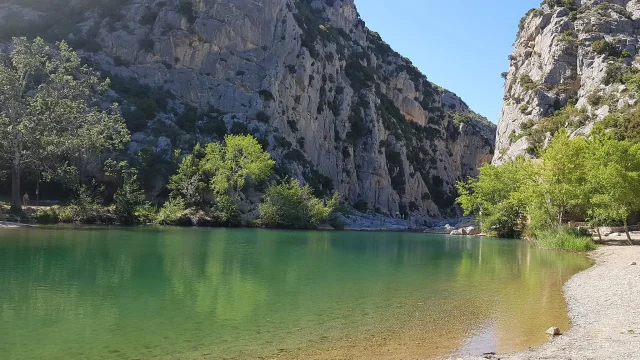 Vue du plan d’eau vert émeraude au pied des falaises des gorges de Gouleyrous à Tautavel.