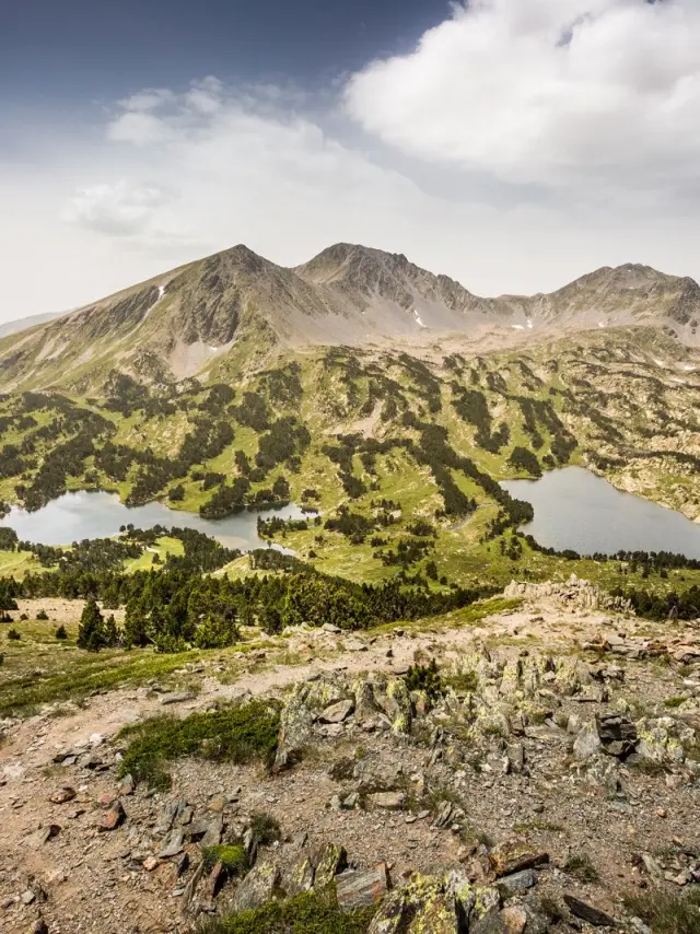 Vue panoramique sur les lacs et les reliefs du massif du Carlit, dans les Pyrénées catalanes, sous un ciel légèrement voilé.