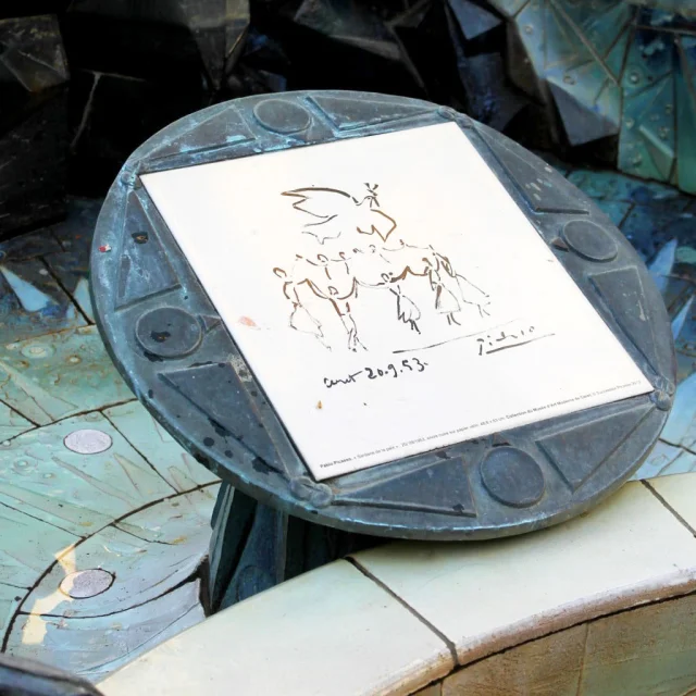 Détail de la fontaine Dali à Céret, montrant une plaque en céramique ornée d’un dessin signé Picasso, intégrée dans l’œuvre colorée.