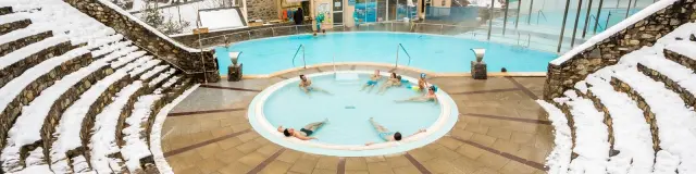 Bains de Saint-Thomas à Fontpédrouse, bassins d’eaux chaudes naturelles en plein air entourés de neige, dans une cuvette de montagne des Pyrénées-Orientales.