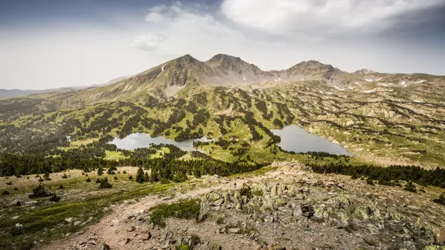 Vue panoramique sur les lacs et les reliefs du massif du Carlit, dans les Pyrénées catalanes, sous un ciel légèrement voilé.