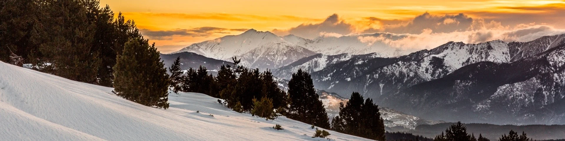 Lever de soleil sur le massif du Canigó et les Pyrénées, vu depuis le plateau enneigé de La Calme à Font-Romeu.