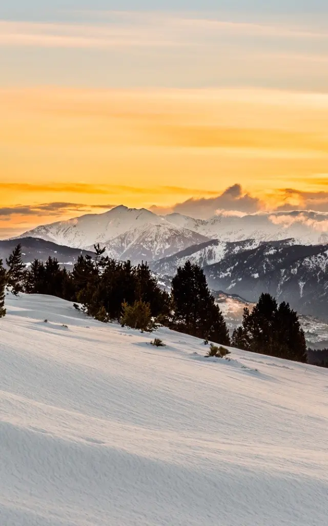 Lever de soleil sur le massif du Canigó et les Pyrénées, vu depuis le plateau enneigé de La Calme à Font-Romeu.