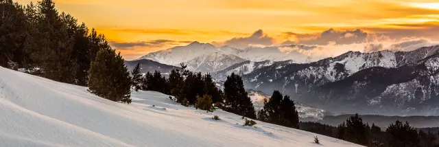 Lever de soleil sur le massif du Canigó et les Pyrénées, vu depuis le plateau enneigé de La Calme à Font-Romeu.