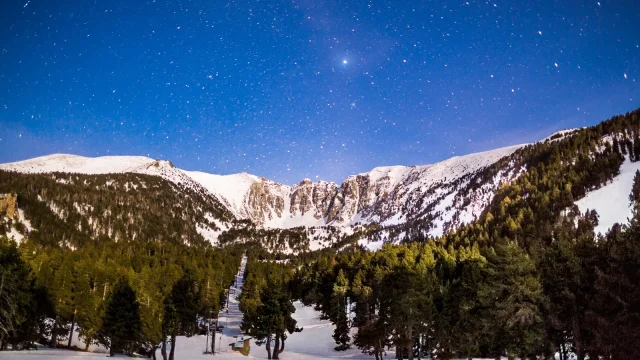 Le massif du Cambre d’Aze sous un ciel étoilé, photographié de nuit depuis la station d’Eyne lors d’une randonnée en raquettes dans les Pyrénées Catalanes.