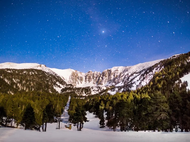 Le massif du Cambre d’Aze sous un ciel étoilé, photographié de nuit depuis la station d’Eyne lors d’une randonnée en raquettes dans les Pyrénées Catalanes.