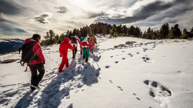 Groupe de randonneurs en raquettes progressant sur un sentier enneigé au sommet du Très Estelle, à Sahorre, dans le Haut Conflent, Pyrénées-Orientales.