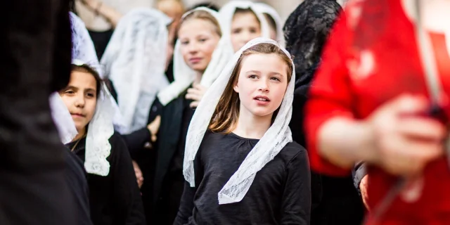 Jeunes participantes vêtues de noir et portant un voile blanc en dentelle lors de la Procession de la Sanch à Perpignan.