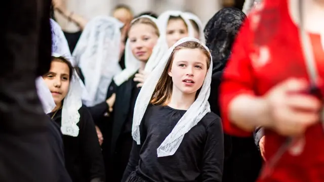Jeunes participantes vêtues de noir et portant un voile blanc en dentelle lors de la Procession de la Sanch à Perpignan.