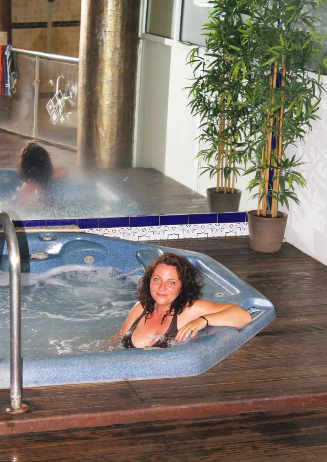 Personne se relaxant dans un jacuzzi intérieur d’un centre de bien-être.