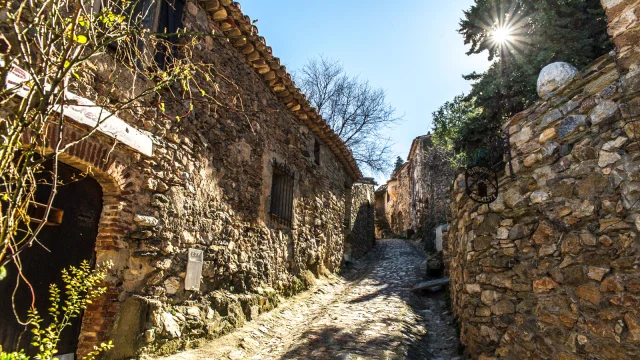 Ruelle pavée et maisons en pierre du village médiéval de Castelnou, classé parmi les Plus Beaux Villages de France, dans les Aspres.