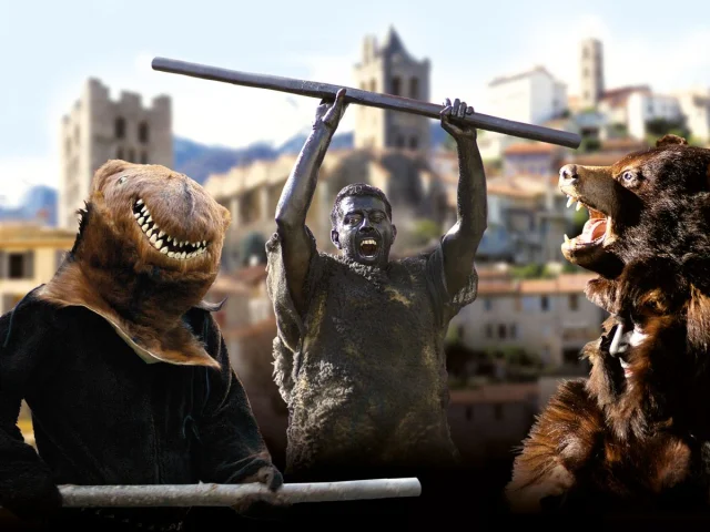 Personnages costumés incarnant la Fête de l’Ours dans un village des Pyrénées, avec des participants grimés et des costumes d’ours sur fond de clochers et de montagnes.