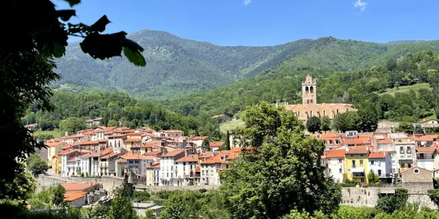 Vue générale du village fortifié de Prats-de-Mollo-La-Preste, dominé par l’église Saintes-Juste-et-Ruffine, au cœur des montagnes verdoyantes du Haut-Vallespir.