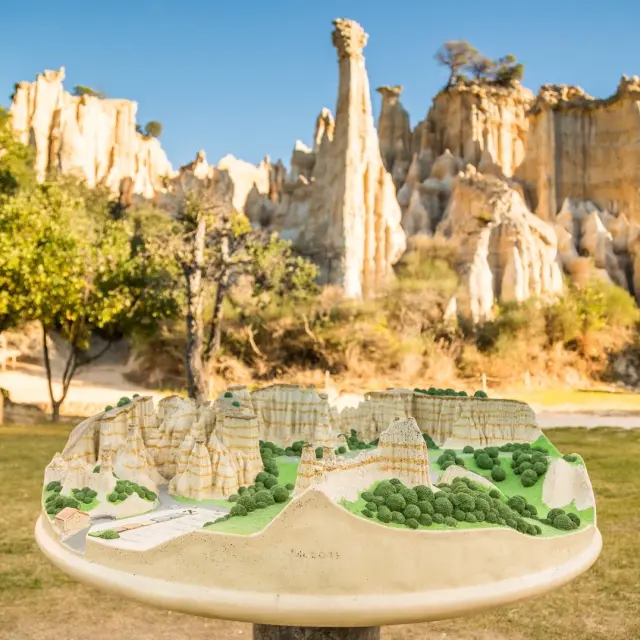 Maquette en relief des Orgues d’Ille-sur-Têt présentée devant les formations rocheuses réelles.