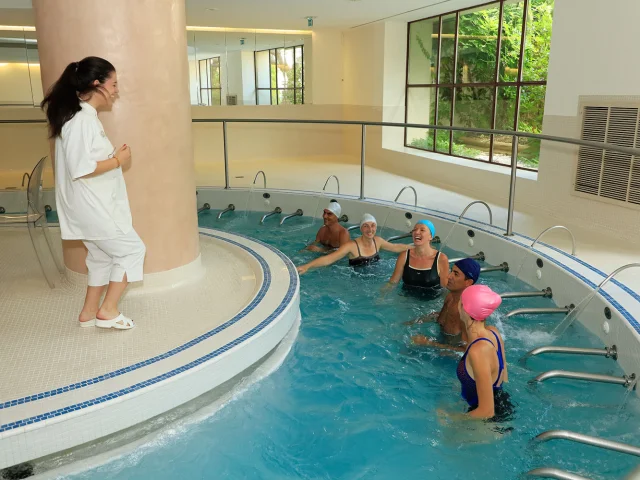 Curistes participant à un cours d’aquagym dans une piscine thermale intérieure aux Thermes Romains d’Amélie-les-Bains.