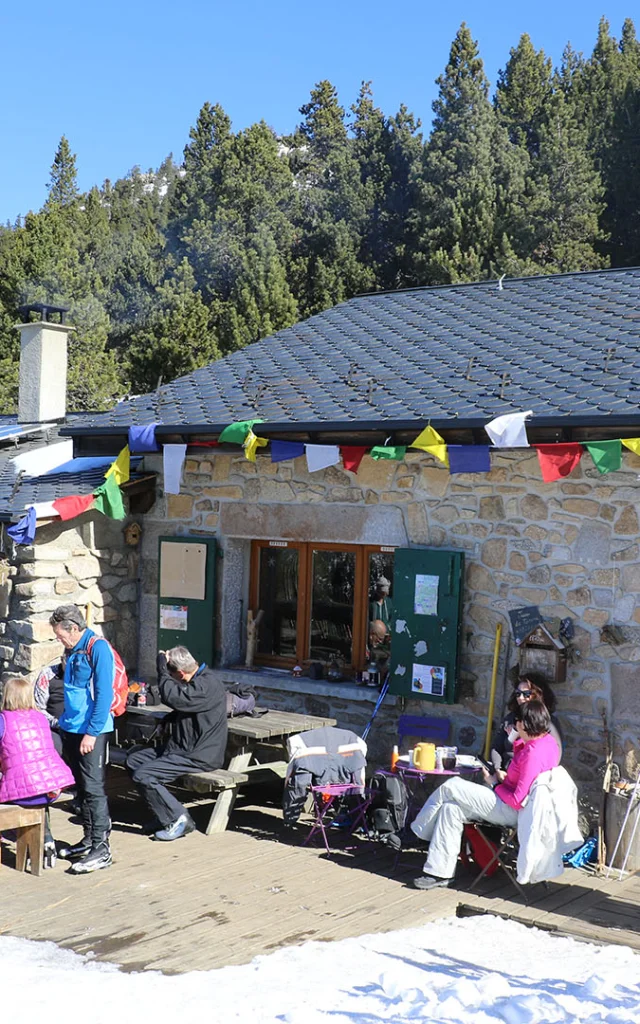 Refuge du Col del Torn à La Llagonne, ensoleillé, avec des visiteurs installés en terrasse.