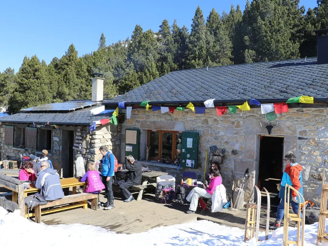 Refuge du Col del Torn à La Llagonne, ensoleillé, avec des visiteurs installés en terrasse.