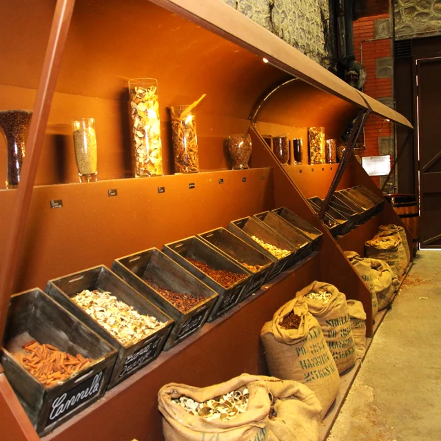 Étal d’épices et de plantes aromatiques exposées à la Cave Byrrh de Thuir, présentant les ingrédients naturels utilisés dans la composition du célèbre apéritif catalan à base de vin et de quinquina.