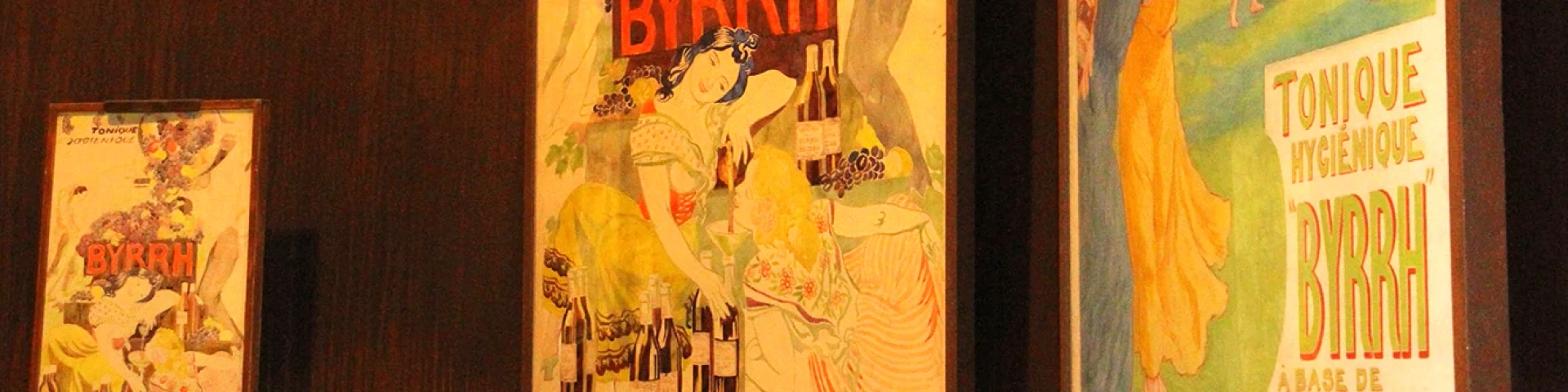Affiches publicitaires anciennes de la marque Byrrh exposées à la Cave Byrrh de Thuir, illustrant l’histoire et l’univers visuel emblématique du célèbre apéritif catalan.