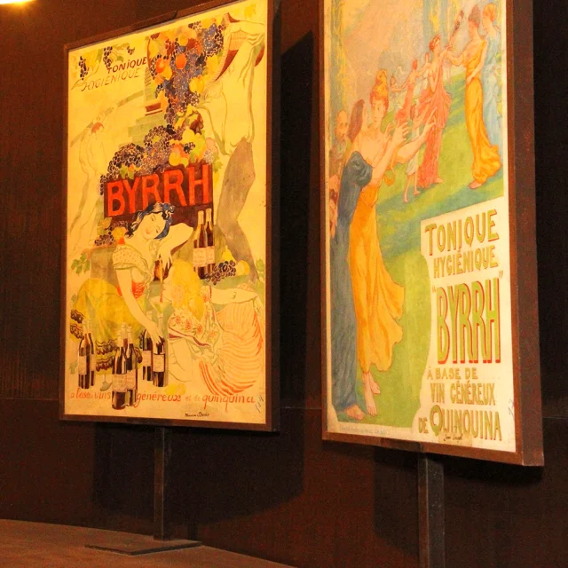 Affiches publicitaires anciennes de la marque Byrrh exposées à la Cave Byrrh de Thuir, illustrant l’histoire et l’univers visuel emblématique du célèbre apéritif catalan.