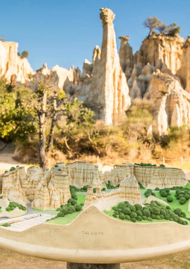 Maquette en relief des Orgues d’Ille-sur-Têt présentée devant les formations rocheuses réelles.