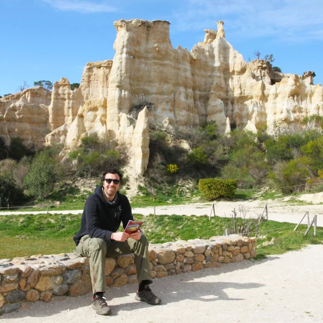 Visiteur assis devant les Orgues d’Ille-sur-Têt, formations rocheuses façonnées par l’érosion.
