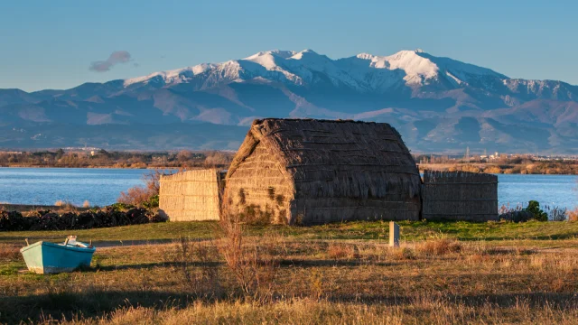 Cabane de pêcheurs au bord de l’étang de Canet-Saint-Nazaire avec le Canigó enneigé en arrière-plan.